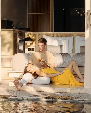 Guests relaxing beside a tropical villa pool
